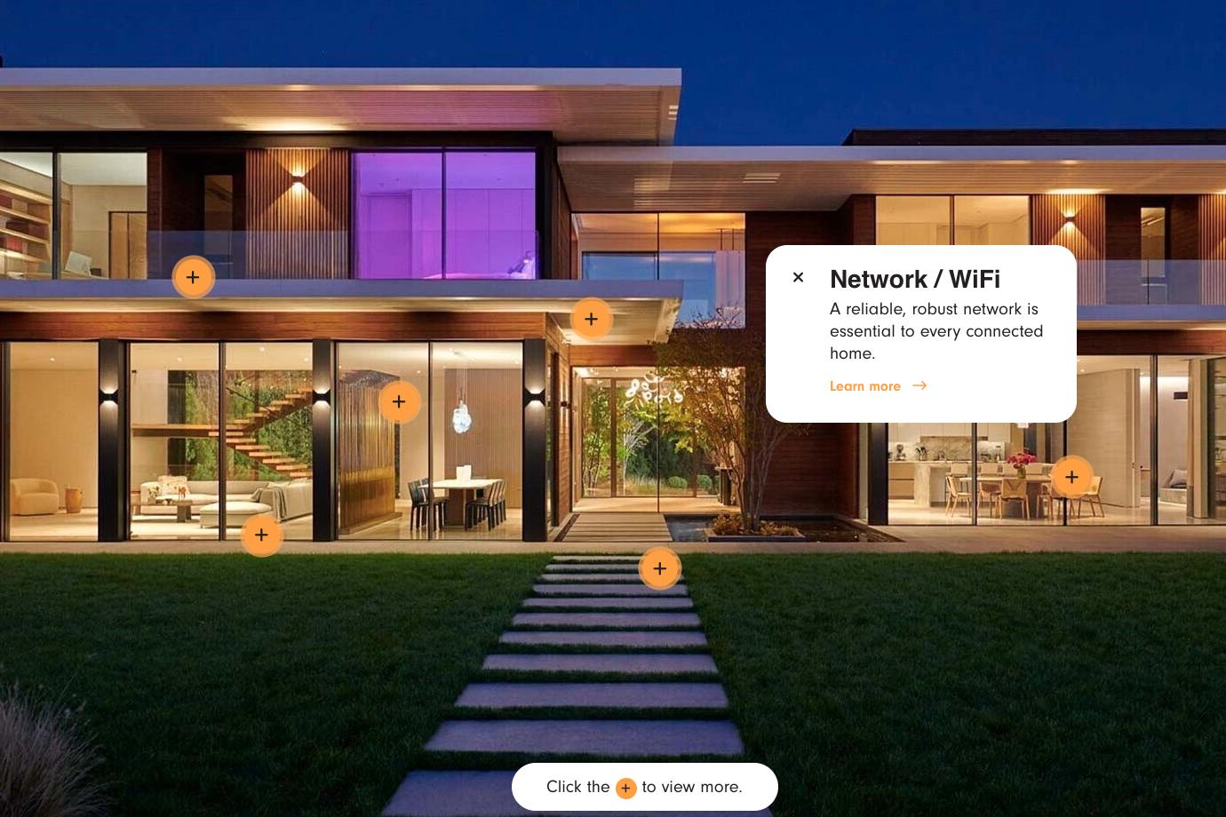 Modern two-story house with large glass windows, lit at night, featuring garden and outdoor path.