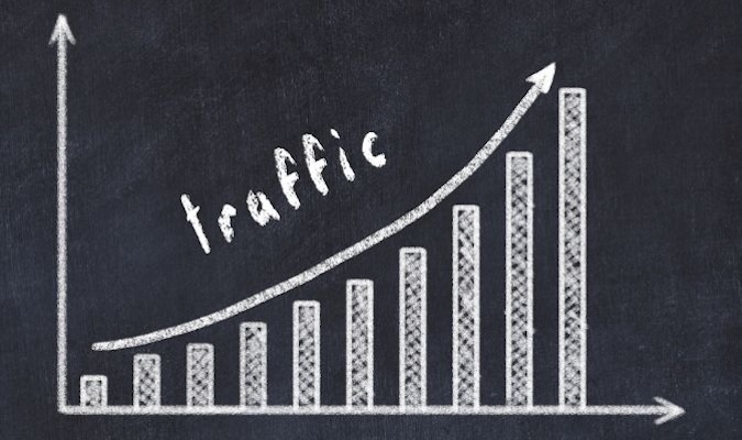 Chalk-drawn bar graph on a blackboard with an upward arrow labeled "traffic," indicating growth.