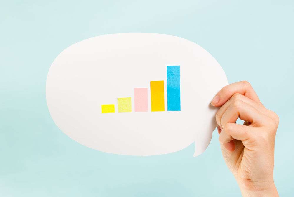 Person Holding Graphic of Bar Graphs