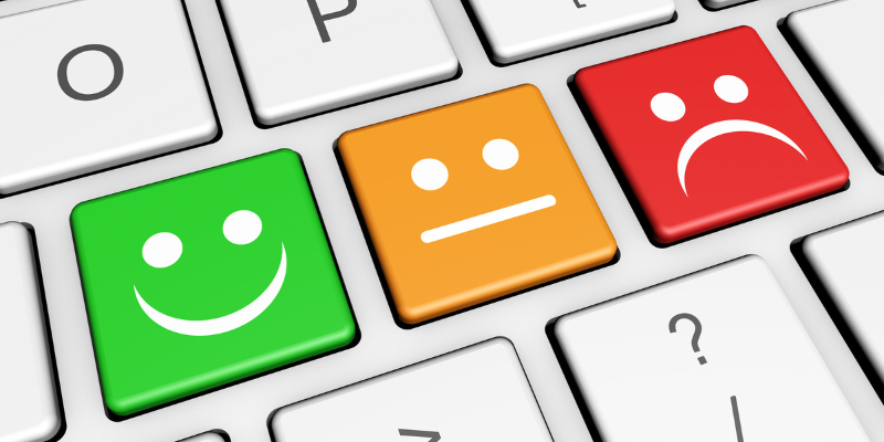 Close-up of keyboard with three keys: green smiling face, orange neutral face, red frowning face