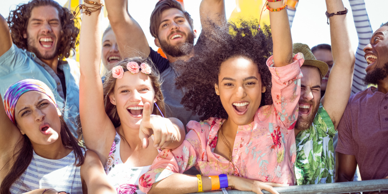 Young adults with hands up in the air having fun.